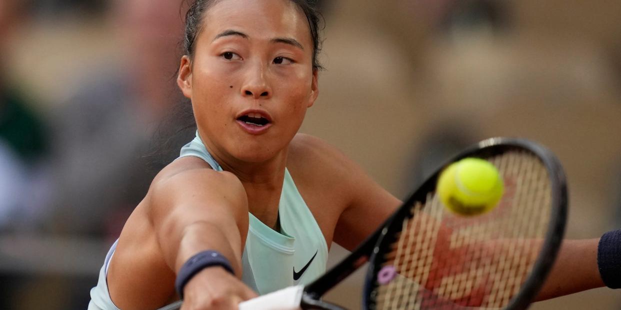 Qinwen Zheng hits a tennis ball with her racket