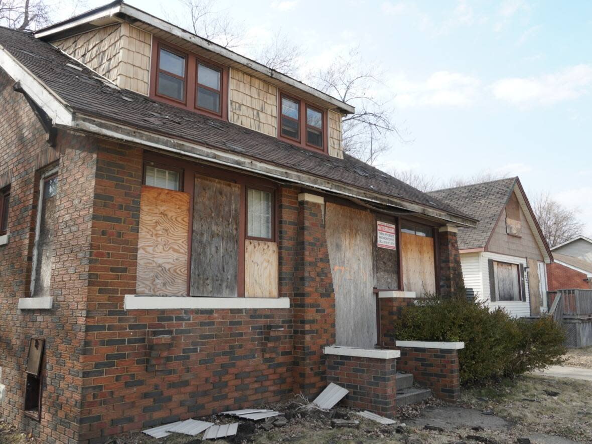 A boarded-up home in Windsor's Sandwich Towne neighbourhood. Homes near the Ambassador Bridge were bought up by the bridge company. Residents would like to see the homes cleaned up and maintained. (Chris Ensing/CBC - image credit)