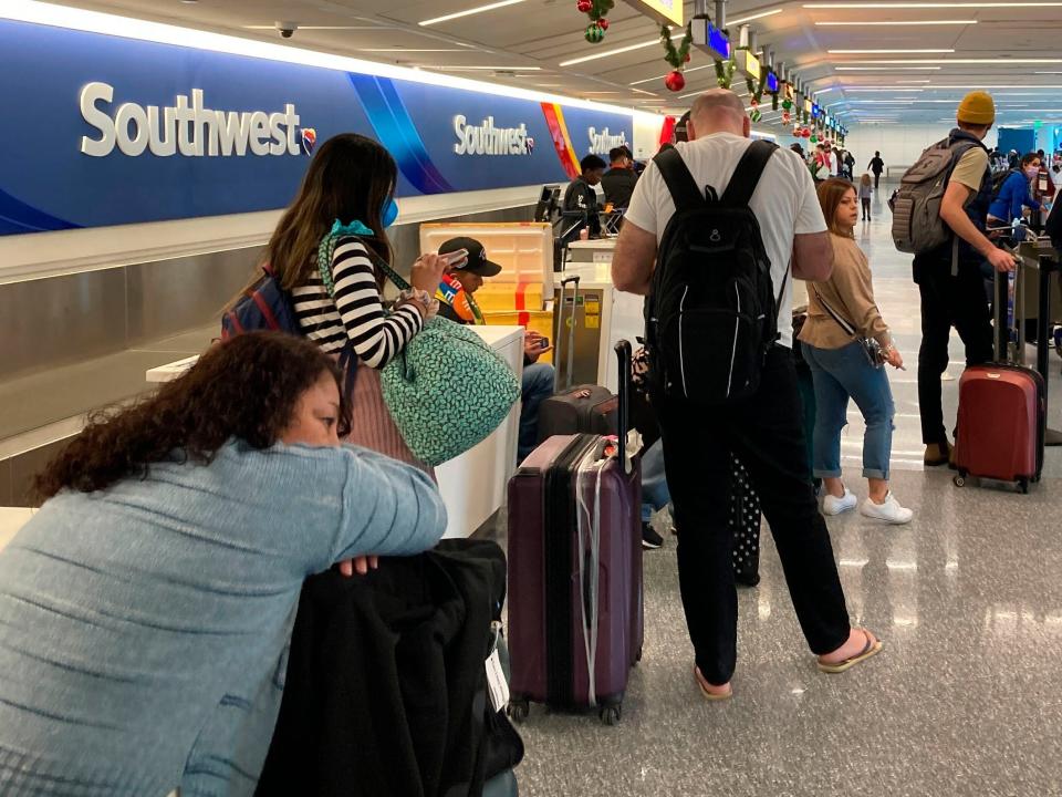 Travelers wait at a Southwest Airlines baggage counter to retrieve their bags after canceled flights at Los Angeles International Airport, Monday, Dec. 26, 2022, in Los Angeles.
