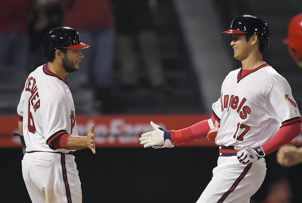 Los Angeles Angels' Shohei Ohtani, right, of Japan, is congratulated by David Fletcher after hitting a three-run home run during the fourth inning of a baseball game against the Colorado Rockies, Monday, Aug. 27, 2018, in Anaheim, Calif. (AP Photo/Mark J. Terrill)