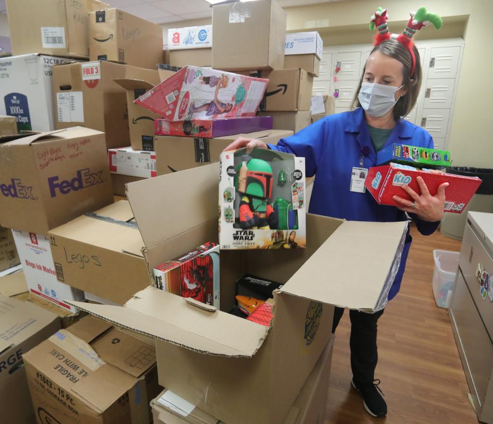 Akron Children's Hospital volunteer Rebecca Pelton unpacks some of the 3,715 toys for patients donated this week by members of the Children's Toy Fund.