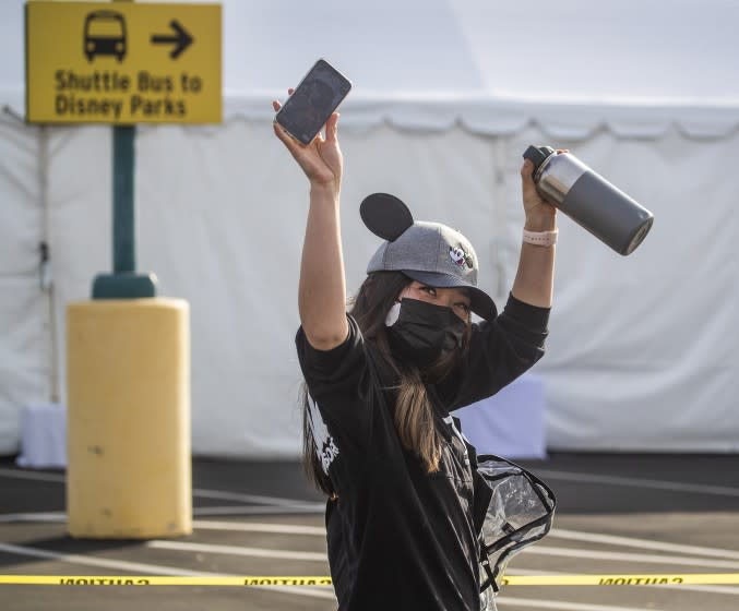 Anaheim, CA - January 13: An Orange County active Phase 1A (critical and healthcare workers) resident wearing Micky Mouse ears hat celebrates as she exits large tents at Orange County's first large-scale vaccination site after receiving the Moderna COVID-19 vaccine in the Toy Story parking lot at the Disneyland Resort in Anaheim Wednesday, Jan. 13, 2021. Orange County supervisors and Orange County Health Care Agency Director Dr. Clayton Chau held a news conference discussing the county's first Super POD (point-of-dispensing) site for COVID-19 vaccine distribution. The vaccinations are at Tier 1A for people who have reservations on a website. The site is able to handle 7,000 immunizations per day. Their goal is to immunize everyone in Orange County who chooses to do so by July 4th. (Allen J. Schaben / Los Angeles Times)