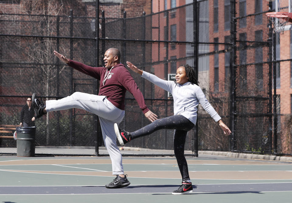 FILE - Fred Frazer, a property manager, exercises with his daughter Olivia, 10, on the Christopher "Biggie" Wallace basketball courts in the Brooklyn borough of New York, in this Thursday, March 26, 2020, file photo. During the pandemic, people around the world sought relief from lock downs and working from home in leisure sports. (AP Photo/Kathy Willens, File)
