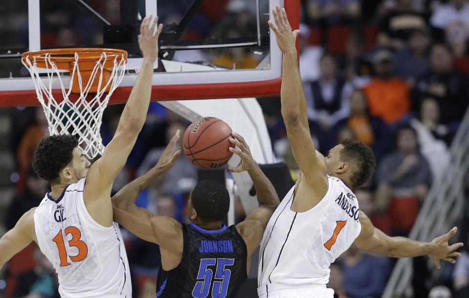 Memphis guard Geron Johnson (55) shoots against Virginia's Anthony Gill (13) and Justin Anderson (1) during the first half of an NCAA college basketball third-round tournament game, Sunday, March 23, 2014, in Raleigh. (AP Photo/Gerry Broome)