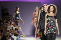 Former model Shalom Harlow, right, wears a creation as part of Versace's women's 2019 Spring-Summer collection, unveiled during the Fashion Week in Milan, Italy, Friday, Sept. 21, 2018. (AP Photo/Antonio Calanni)