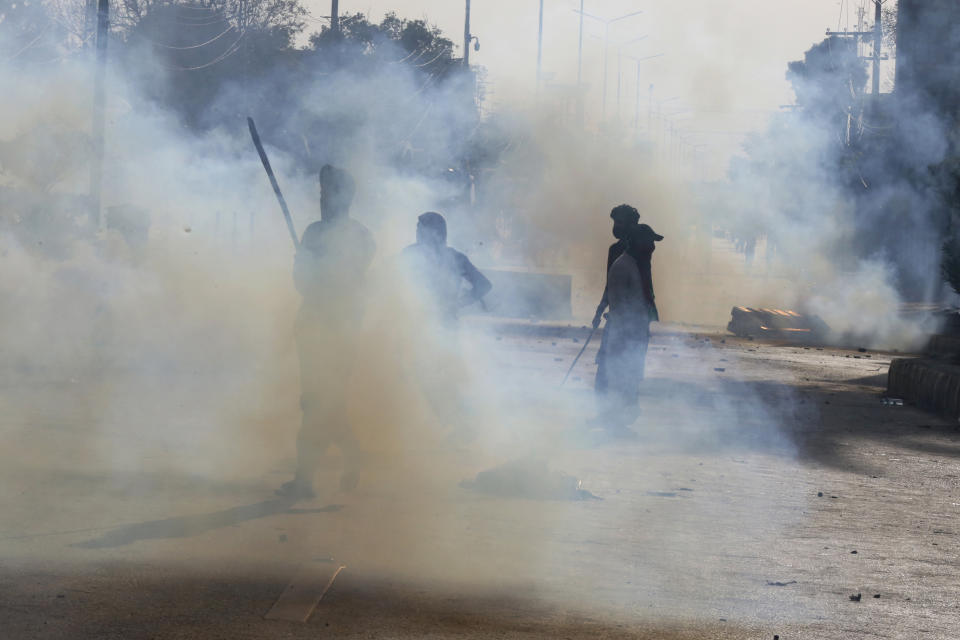 Police fire tear gas to disperse supporters of Pakistan's former Prime Minister Imran Khan protesting against the arrest of their leader, in Peshawar, Pakistan, Tuesday, May 9, 2023. Khan was arrested and dragged from court as he appeared there to face charges in multiple graft cases, a dramatic escalation of political tensions that sparked violent demonstrations by his supporters in major cities. (AP Photo/Muhammad Sajjad)