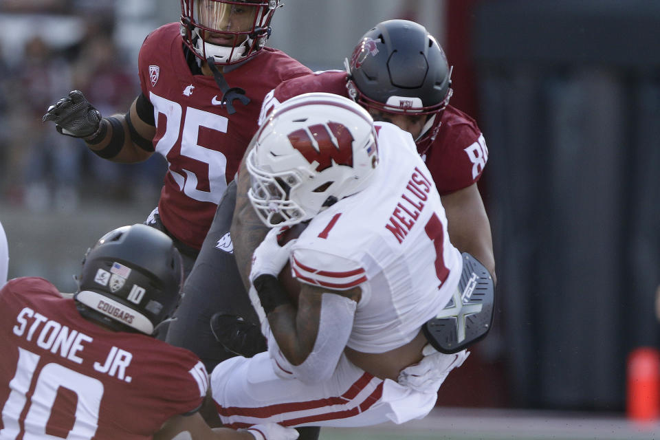 Washington State defensive end Brennan Jackson (80) tackles Wisconsin running back Chez Mellusi (1) during the first half of an NCAA college football game, Saturday, Sept. 9, 2023, in Pullman, Wash. (AP Photo/Young Kwak)
