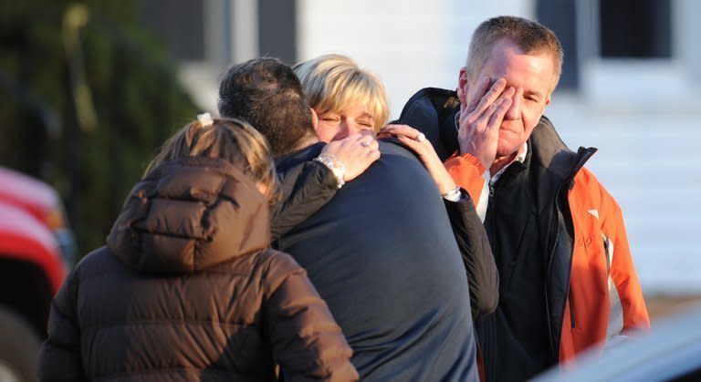 People grieve at the scene of a school shooting in Newtown, Connecticut, on December 14, 2012