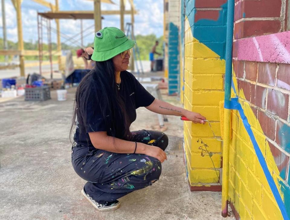 A local artist paints the side of building located at Triangle Arts, a Macon arts incubator.