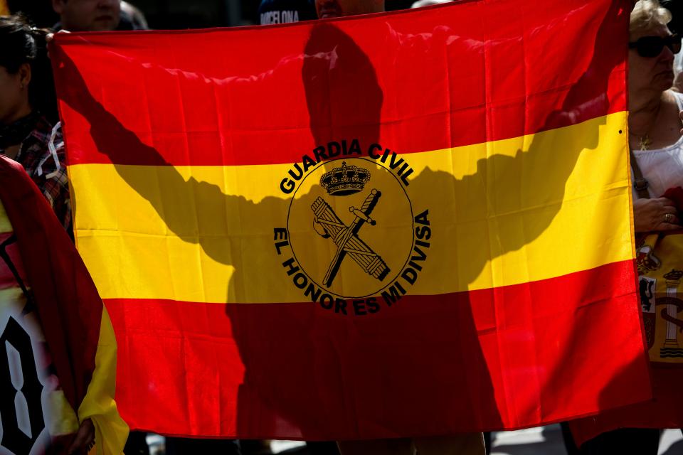 <p>A demonstrator against independence, holds a Spanish flag reading “Civil Guard, the honor is my insignia” during a protest in front of Catalunya Radio headquarters in Barcelona on Sept.27, 2017. Catalonia’s regional police force today warned the Spanish government that a demand from the prosecutor’s office to seal off polling stations and prevent a contested independence referendum could spark civil unrest. (Photo: Josep Lago/AFP/Getty Images) </p>