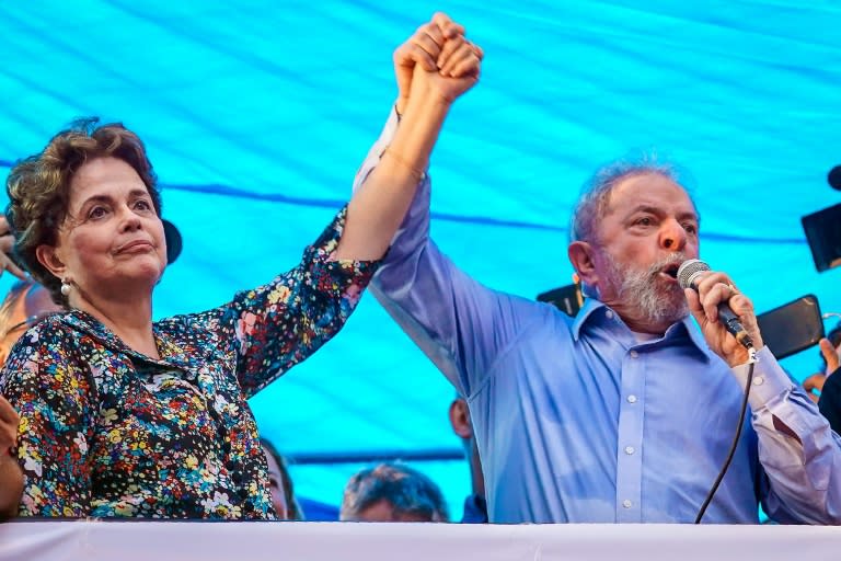 Former Brazilian president Luiz Inacio Lula da Silva (R) is seen clasping hands with former president Dilma Rousseff (L), during a protest in Porto Alegre, where a court is expected to rule on an appeal of his corruption conviction