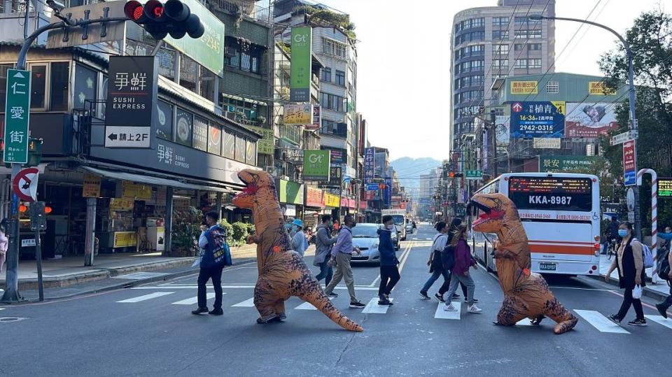 新店有預售案搶搭輕軌捷運開通熱潮，請仲介穿恐龍裝到夜市舉牌打廣告。（圖／漢皇開雲業者提供）