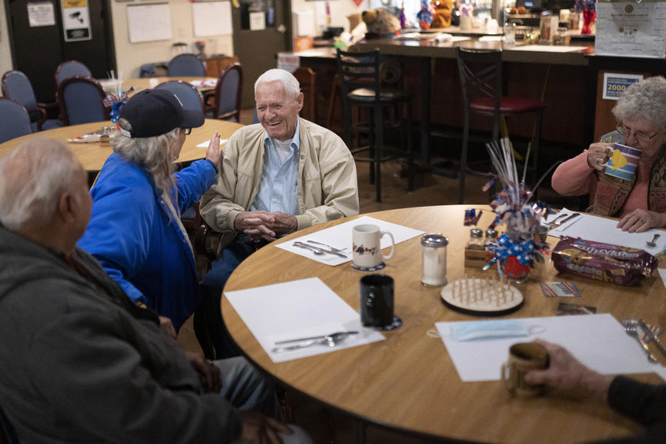 Pearl Harbor survivor and World War II Navy veteran David Russell, 101, center, talks with Denise Emery, center left, and other veterans while eating breakfast at the American Legion Post 10 on Monday, Nov. 22, 2021, in Albany, Ore. (AP Photo/Nathan Howard)