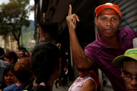 People queue on the street as they try to buy food outside a supermarket in Caracas, Venezuela May 23, 2016. REUTERS/Carlos Garcia Rawlins