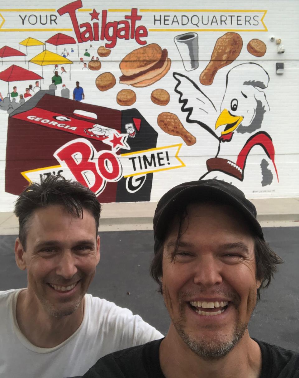 Brothers Rame and Will Eskridge (L-R) take a celebratory selfie on Jun. 28, 2022 after completing their mural at the Atlanta Highway Bojangles location in Athens, Ga.