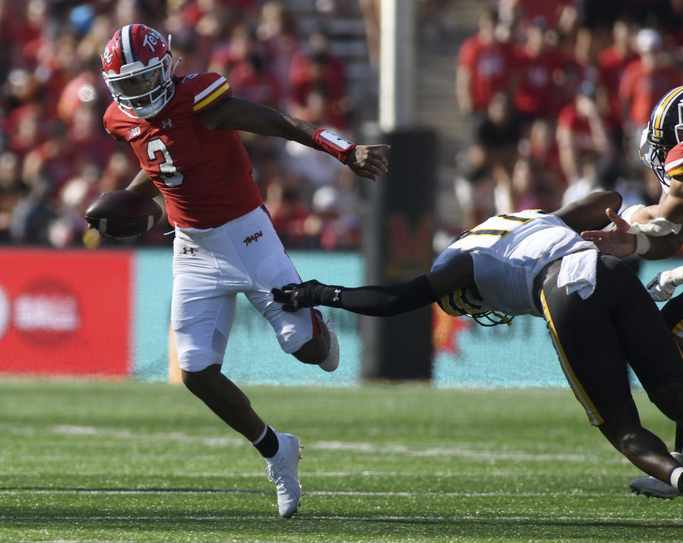 Maryland quarterback Taulia Tagovailoa (3) escapes a tackle from Towson defensive lineman Olyfride Okombi (11) in the first half of an NCAA football game Saturday, Sept. 2, 2023, in College Park, Md. (AP Photo/Steve Ruark)