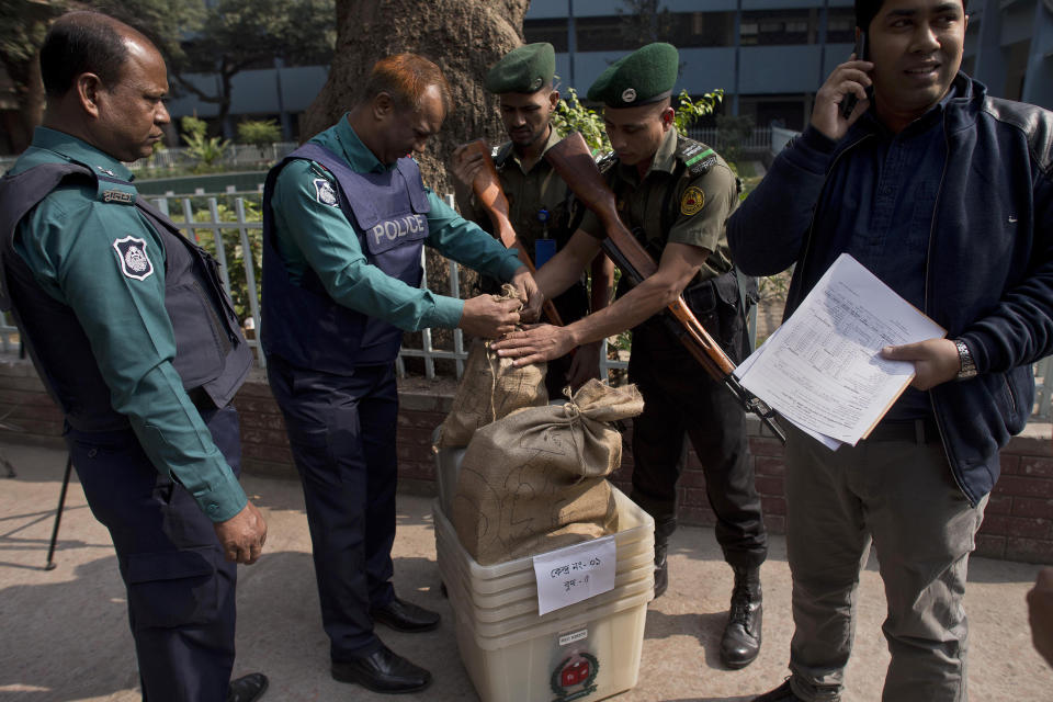 Bangladeshi police personnel seal the voting material at a distribution center before being transported to polling stations on the eve of the general elections in Dhaka, Bangladesh, Saturday, Dec. 29, 2018. As Bangladeshis get set for Sunday's parliamentary elections, there are fears that violence and intimidation could keep many away from the polls, including two opposition candidates who said police had barricaded them inside their homes. (AP Photo/Anupam Nath)