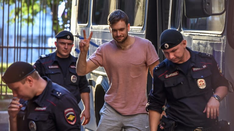 Pussy Riot punk group activist Pyotr Verzilov (C) with police outside a courthouse in Moscow earlier this year