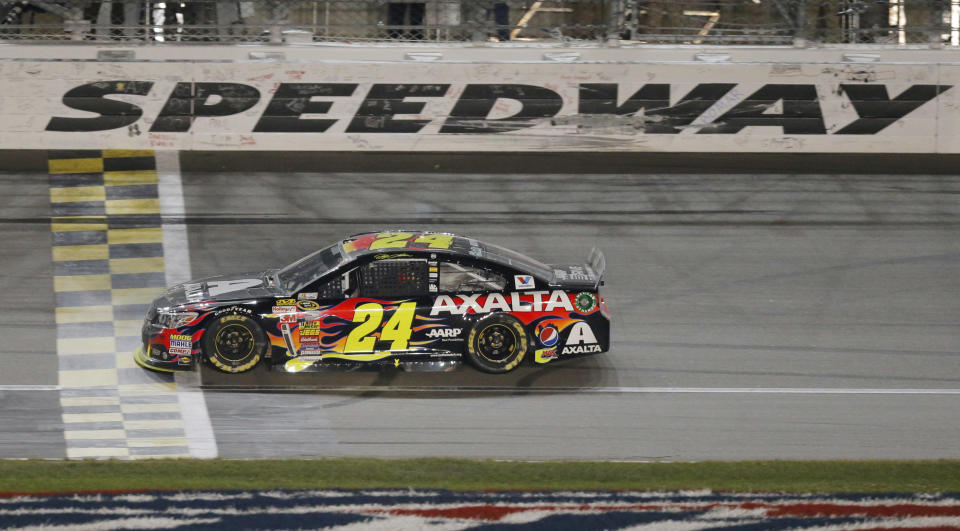 NASCAR driver Jeff Gordon (24) crosses the finish line to win the Sprint Cup Series auto race at Kansas Speedway in Kansas City, Kan., Saturday, May 10, 2014. (AP Photo/Orlin Wagner)