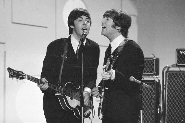 <p>CBS Photo Archive/Getty Images</p> (L-R) Paul McCartney and John Lennon sing into a microphone at the taping of a segment for 'Toast of the Town' in August 1965.