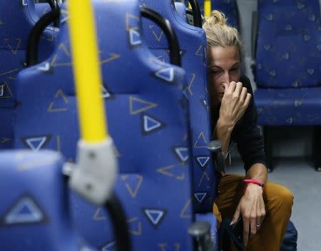 Journalist Joanna Moyse cries on an official media bus after a window shattered when driving accredited journalists to the Main Transport Mall from the Deodoro venue of the Rio 2016 Olympic Games in Rio de Janeiro, August 9, 2016. REUTERS/Shannon Stapleton