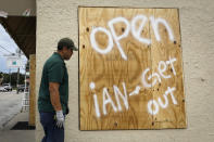 <p>A storefront sign in Tampa reads "Open, Ian Get Out," on Sept. 27.</p>