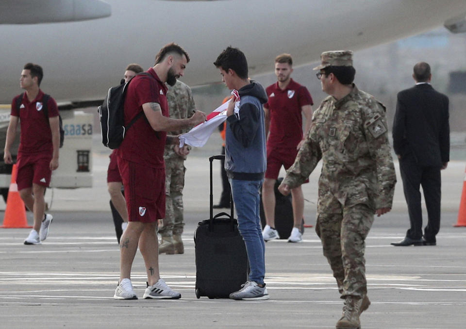 Lucas Pratto of Argentina's River Plate, signs a fan's t-shirt, after his team arrived at the military airport Grupo Aereo 8, in Lima, Peru, Wednesday, Nov. 20, 2019. The team will play Brazil's Flamengo on Saturday's Copa Libertadores final. (AP Photo/Martin Mejia)