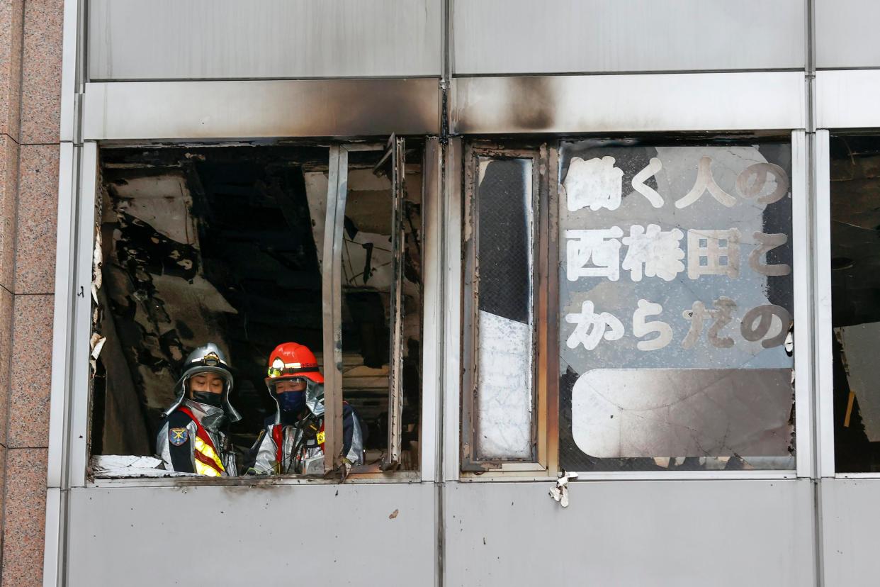 Firefighters stand on a floor at a building where a fire broke out in Osaka, western Japan Friday, Dec. 17. 