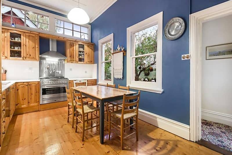 Wooden cabinets in blue painted kitchen.