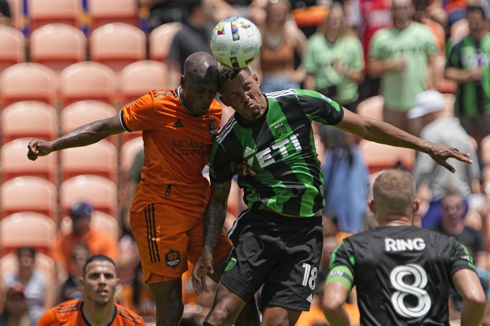 Austin FC's Julio Cascante (18) and Houston Dynamo's Fafà Picault go up to head the ball during the first half of a MLS soccer match Saturday, April 30, 2022, in Houston. (AP Photo/David J. Phillip)