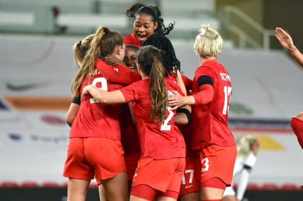 Canada players celebrate a goal against England during a friendly match on Tuesday in Stoke-on-Trent, England. (Rui Vieira/The Associated Press - image credit)