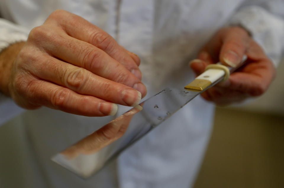 An Orthodox rabbi checks his knife in a Kosher slaughterhouse in Csengele, Hungary on Jan. 15, 2021. Hungarian Jewish community, exporter of Kosher meat, fear that the European Court of Justice verdict on upholding a Belgian law that banned ritual slaughter could have an affect on other EU member states' regulation on Kosher slaughter. (AP Photo/Laszlo Balogh)