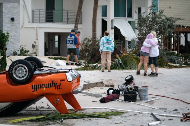 People embrace as they survey property damage in Bonita Springs on Sept. 29. (Photo: Sean Rayford via Getty Images)