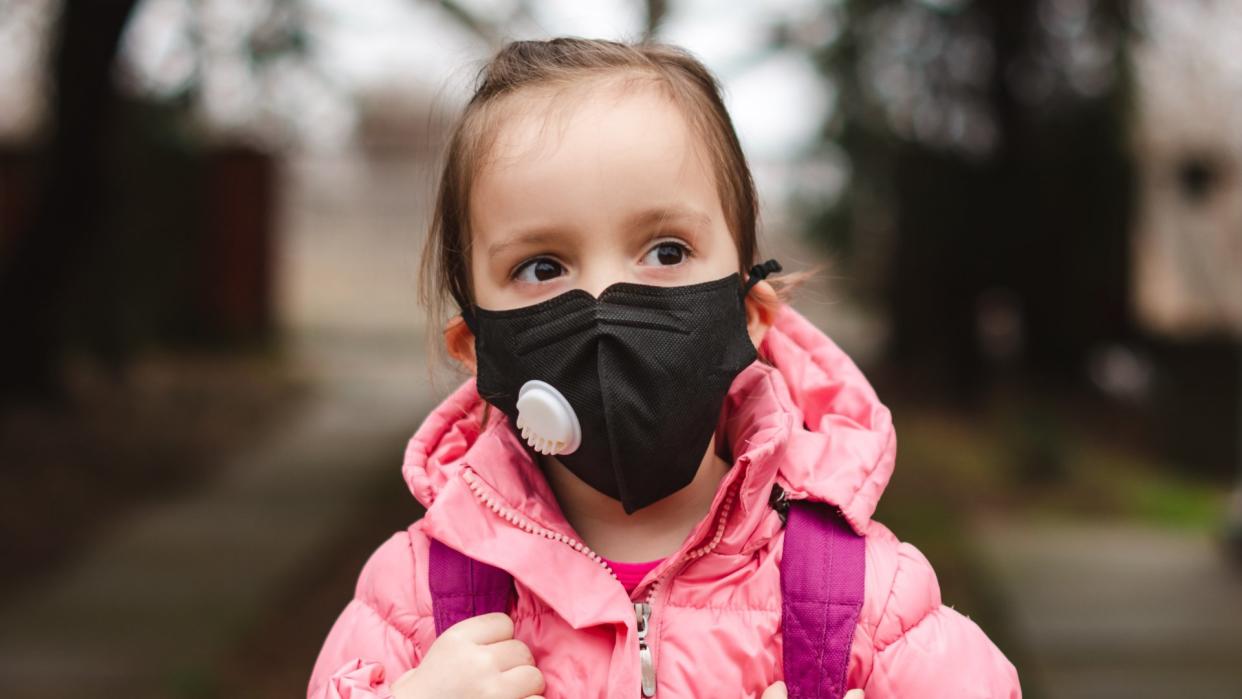 Portrait of a little girl wearing pollution mask going to kindergarten.