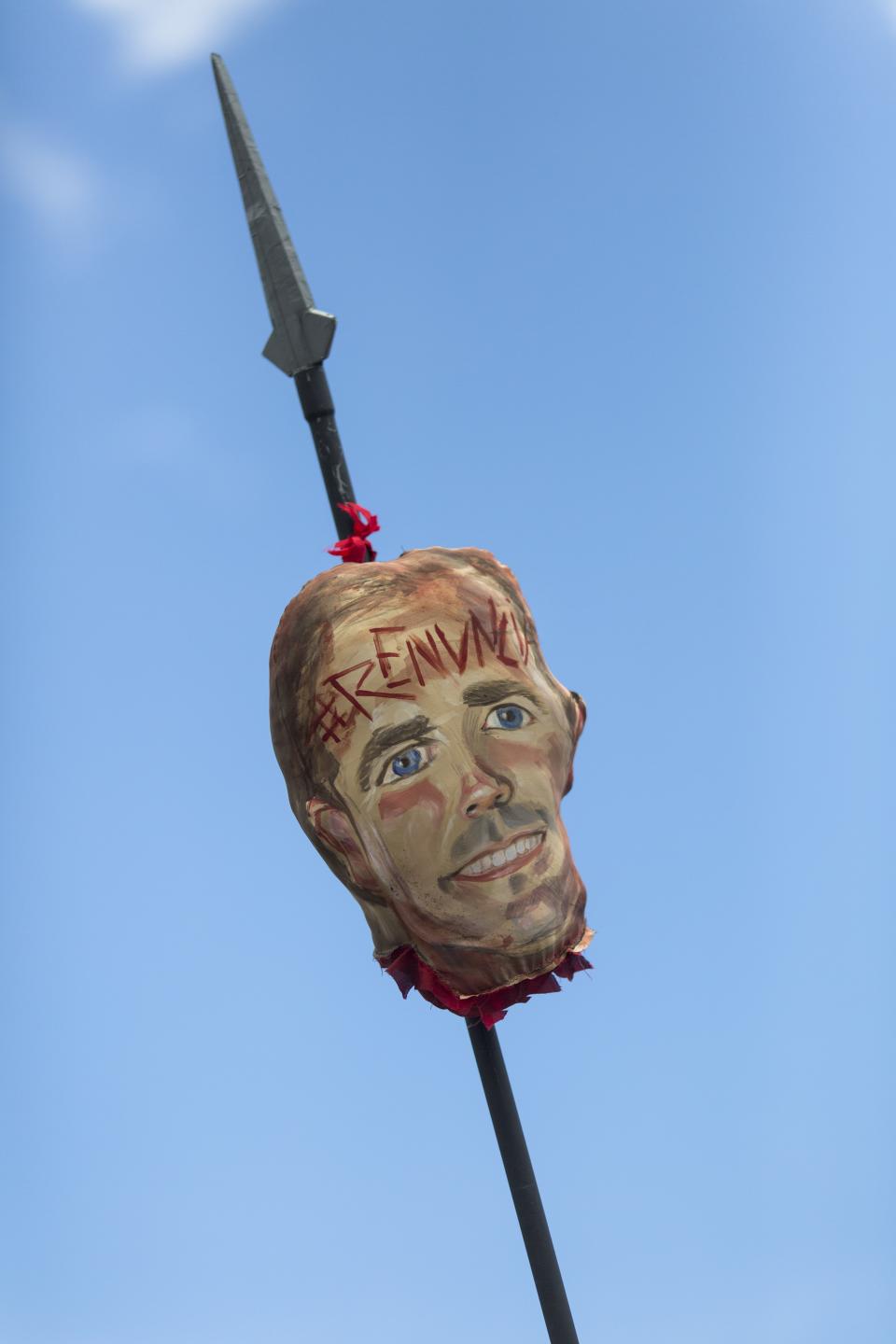 Demonstrators carry a image representing the head of Governor Ricardo Rossello on a pike, with an inscription on its forehead that reads in Spanish "Resign" during a march demanding the resignation of Governor Rossello, in San Juan, Puerto Rico, Monday, July 22, 2019. Protesters are demanding Rossello step down for his involvement in a private chat in which I have used profanities to describe an ex-New York City councilwoman and a federal control board overseeing the island's finance. (AP Photo / Dennis M. Rivera Pichardo)