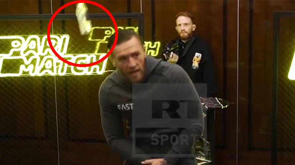 Conor McGregor ducks as a bottle is hurled his way.