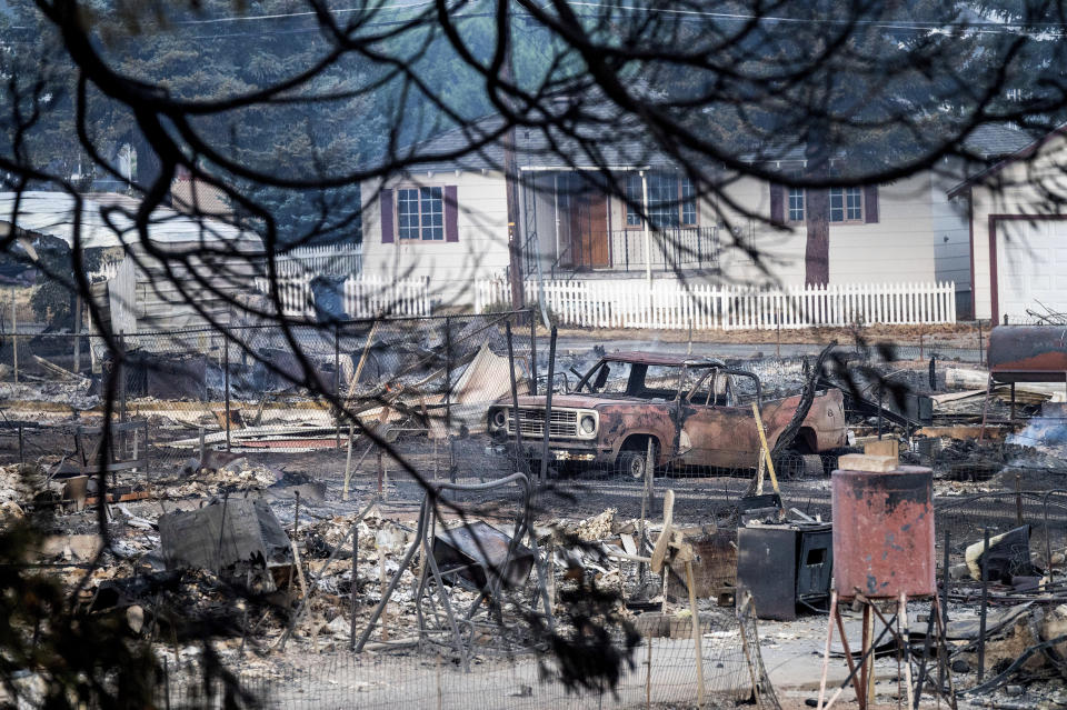 A vehicle rests amid homes leveled by the Mill Fire in Weed, Calif., on Saturday, Sept. 3, 2022. (AP Photo/Noah Berger)