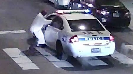 A still image from surveillance video shows a gunman (L) approaching a Philadelphia Police vehicle in which Officer Jesse Hartnett was shot shortly before midnight in Philadelphia, Pennsylvania this Philadelphia Police Department image released on January 8, 2016. REUTERS/Philadelphia Police Department/Handout