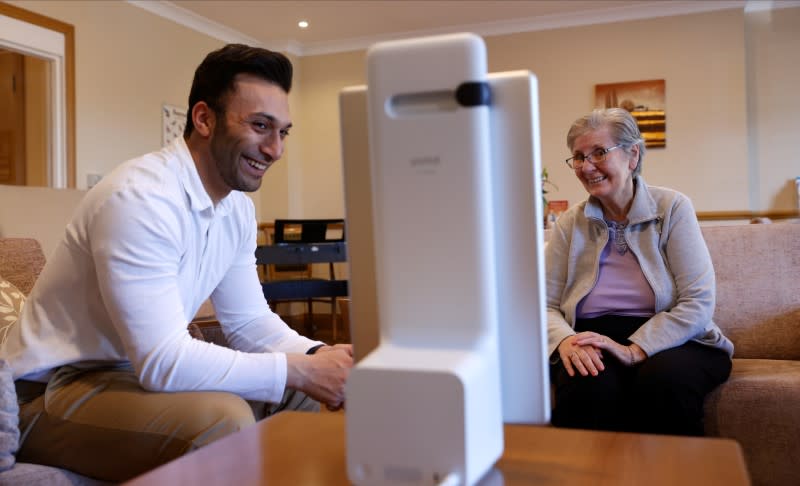 Resident Tolson chats via Facebook Portal to her family, helped by estate manager Gandecha at the Foxholes Care Home