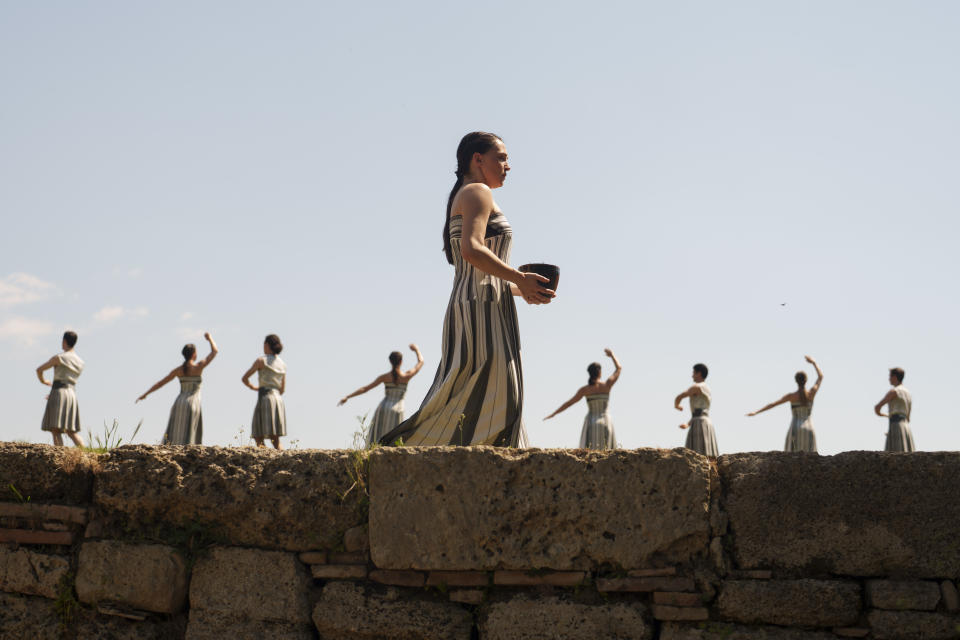 Performers, who will take part in the flame lighting ceremony for the Paris Olympics, join a rehearsal at Ancient Olympia site, Greece, Sunday, April 14, 2024. Every two years, a countdown to the Olympic games is launched from its ancient birthplace with a flame lighting ceremony in southern Greece at Ancient Olympia. The event is marked with a performance by dancers who assume the role of priestesses and male companions, their movement inspired by scenes on millennia-old artwork. (AP Photo/Petros Giannakouris)