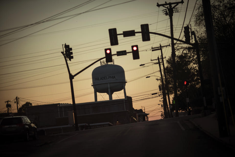 A water tower is framed by electrical wires and traffic lights at sunset in Philadelphia, Miss., Monday, Oct. 5, 2020. (AP Photo/Wong Maye-E)