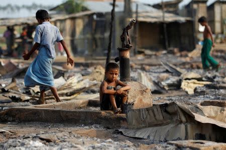 A boy sit in a burnt area after fire destroyed shelters at a camp for internally displaced Rohingya Muslims in the western Rakhine State near Sittwe, Myanmar May 3, 2016. REUTERS/Soe Zeya Tun