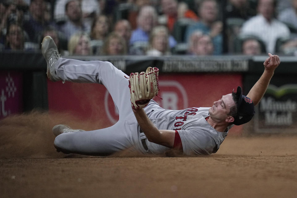 Boston Red Sox relief pitcher Garrett Whitlock makes a sliding catch behind the plate on a pop foul by Houston Astros' Alex Bregman during the seventh inning of a baseball game Wednesday, Aug. 23, 2023, in Houston. (AP Photo/Kevin M. Cox)