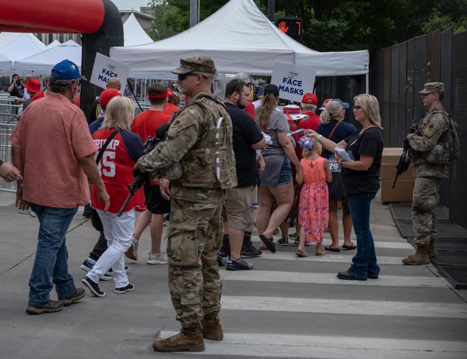 A woman hands out face masks to Trump supporters ahead of US President Donald Trump's campaign rally in Tulsa, Oklahoma June 20,2020. - Hundreds of supporters lined up early for Donald Trump's first political rally in months, saying the risk of contracting COVID-19 in a big, packed arena would not keep them from hearing the president's campaign message. (Photo by SETH HERALD / AFP) (Photo by SETH HERALD/AFP via Getty Images)