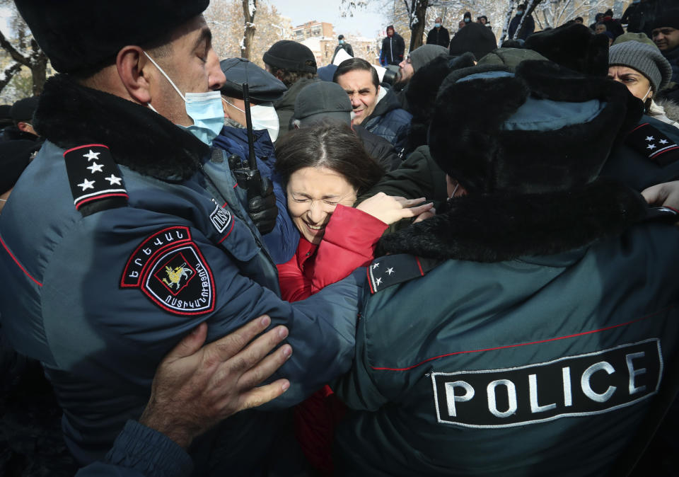 Demonstrators scuffle with Armenian police during a rally to pressure Armenian Prime Minister Nikol Pashinyan to resign over a peace deal with neighboring Azerbaijan on Republic Square in Yerevan, Armenia, Thursday, Dec. 24, 2020. Armenian opposition politicians and their supporters have been protesting for weeks, demanding the prime minister's resignation over his handling of the Nagorno-Karabakh conflict with Azerbaijan. (Vahram Baghdasaryan, Photolure via AP)