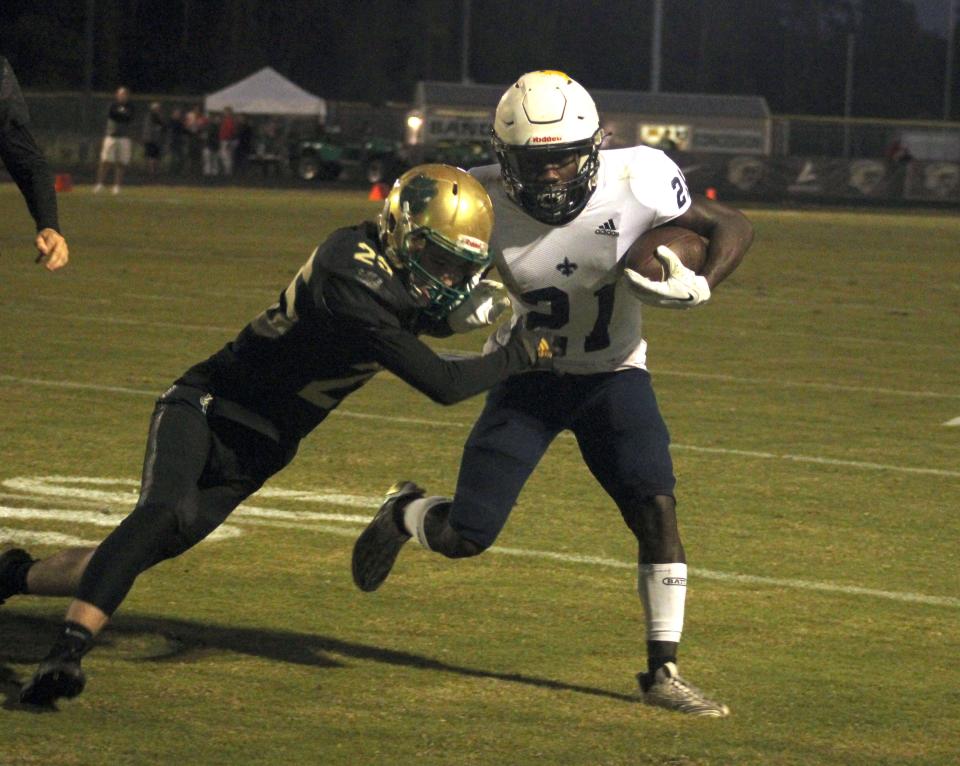 Sandalwood running back Jordan Bean (21) tries to ward off the tackle of Nease defensive back Canon McClafferty (25) during a high school football game on October 4, 2022. [Clayton Freeman/Florida Times-Union]