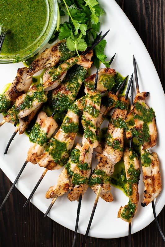 <p>Kitchen Swagger</p><p>Grilled chicken served with a tangy, Argentinian herb-based sauce made with fresh parsley, cilantro, garlic, olive oil, and spices.</p><p><strong>Get the recipe: <a href="https://kitchenswagger.com/grilled-chicken-kebabs-with-chimichurri-sauce-recipe/" rel="nofollow noopener" target="_blank" data-ylk="slk:Grilled Chimichurri Chicken Skewers;elm:context_link;itc:0;sec:content-canvas" class="link "><em>Grilled Chimichurri Chicken Skewers</em></a></strong></p>