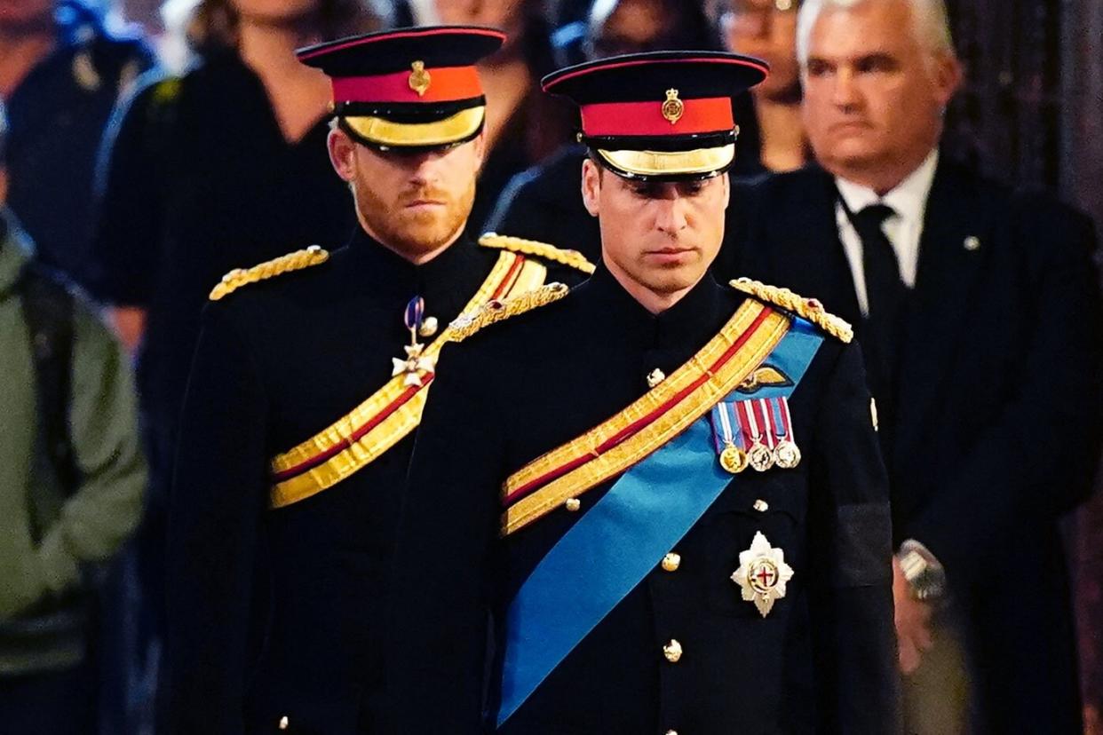 Queen Elizabeth II 's grandchildren (L-R) Britain's Prince Harry, Duke of Sussex (L) and Britain's Prince William, Prince of Wales (R) arrive to hold a vigil around the coffin of Queen Elizabeth II, in Westminster Hall, at the Palace of Westminster in London on September 17, 2022, ahead of her funeral on Monday. - Queen Elizabeth II will lie in state in Westminster Hall inside the Palace of Westminster, until 0530 GMT on September 19, a few hours before her funeral, with huge queues expected to file past her coffin to pay their respects. (Photo by Aaron Chown / POOL / AFP) (Photo by AARON CHOWN/POOL/AFP via Getty Images)