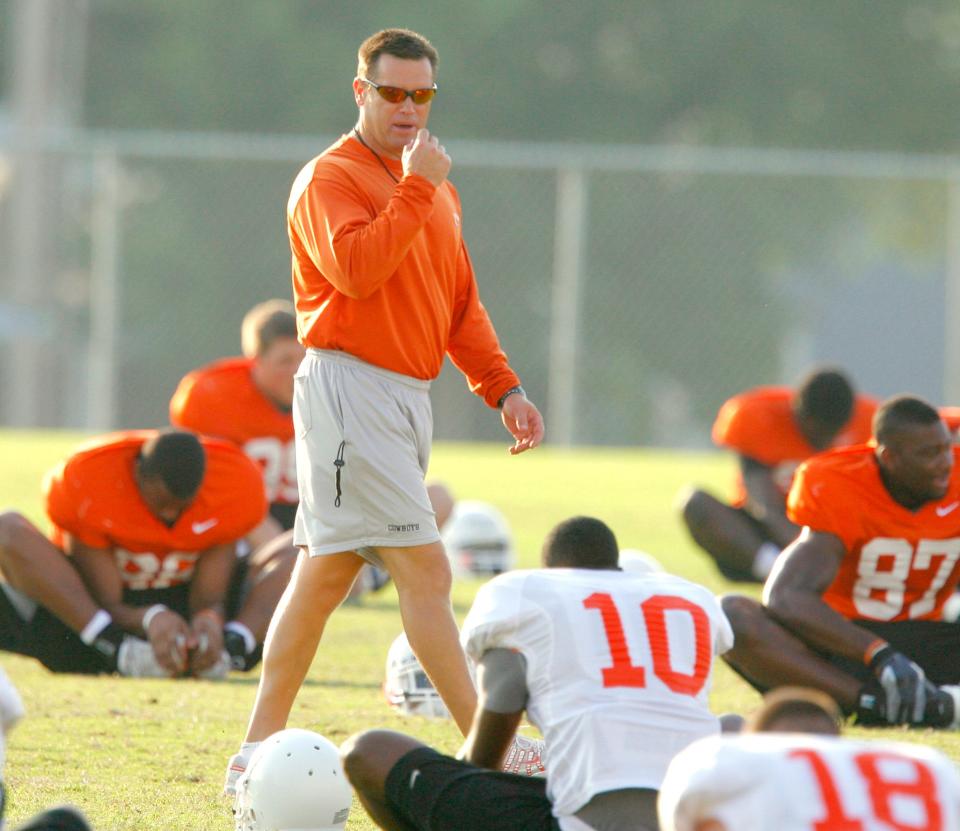 OSU strength and conditioning coach Rob Glass leads the team in stretching during during a 2008 practice.