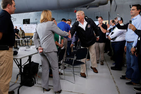 U.S. President Donald Trump shakes hands with San Juan Mayor Carmen Yulin Cruz before a briefing to survey hurricane damage, at Muniz Air National Guard Base in Carolina, Puerto Rico, U.S. October 3, 2017. REUTERS/Jonathan Ernst